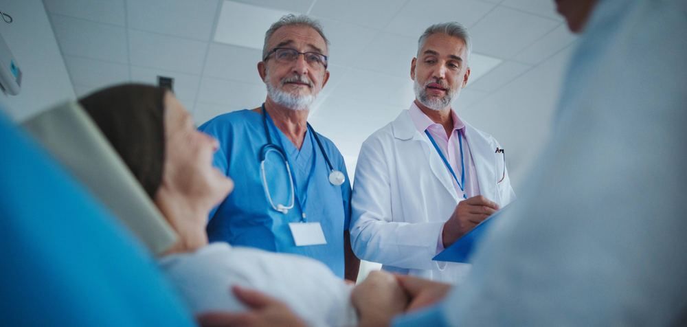 Two doctors speaking with a patient at the hospital bedside | Doctor in Olympos-Cirali | Online Doctor & Online Prescription | E-rx.online