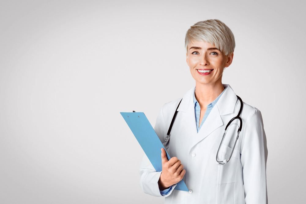Smiling female doctor holding a clipboard | Izmir Traveller Health Guide | Online Doctor | E-rx.online