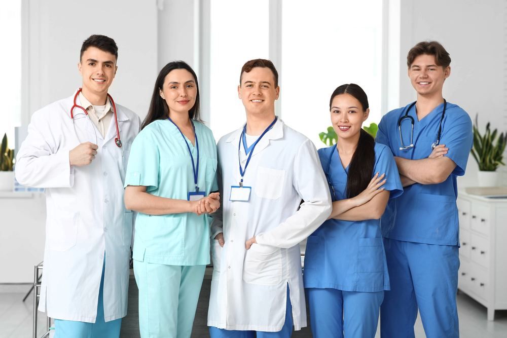 Patient-First Health Guides | Online Prescription | Smiling team of five doctors and nurses in a bright clinic | E-rx.online