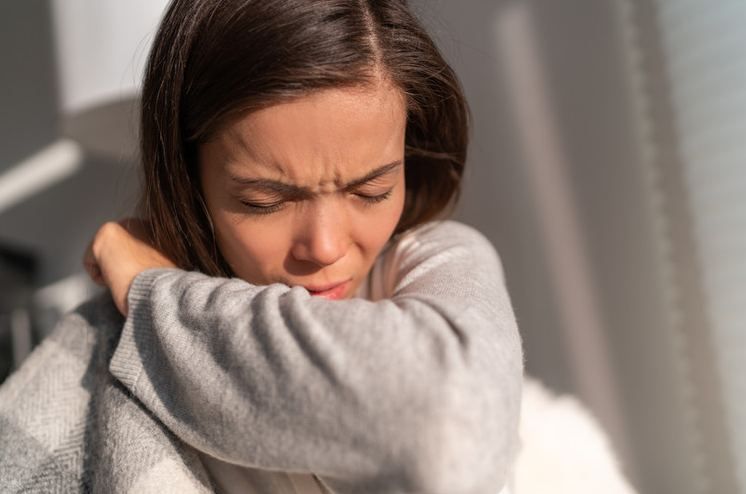 Find a 24/7 On-Call Doctor for Bronchitis Treatment, | Online Prescription | Woman coughing into her elbow with cold and flu symptoms | E-rx.online